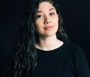 Female employee wearing black shirt with grey background 