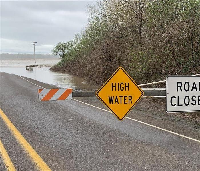Highway with caution sign and water rising 