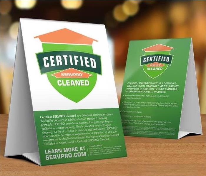  Table tent signs describing the Certified: SERVPRO Cleaned program on top of a wooden table