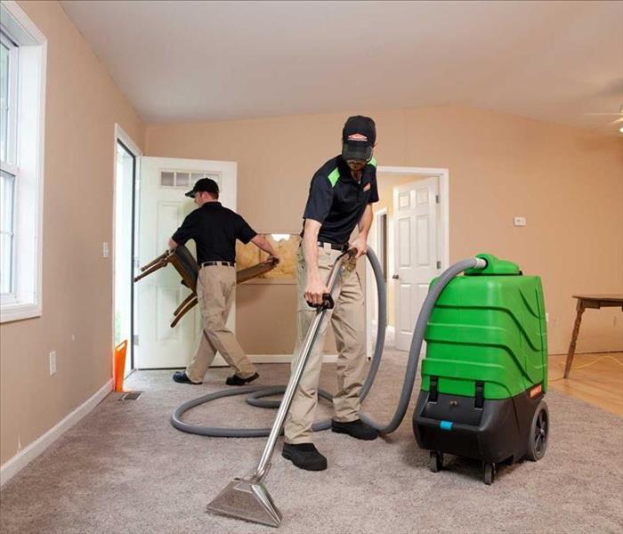 Servpro employee cleaning white carpet 