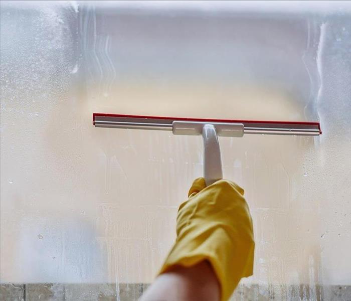 Window being cleaned with yellow gloves